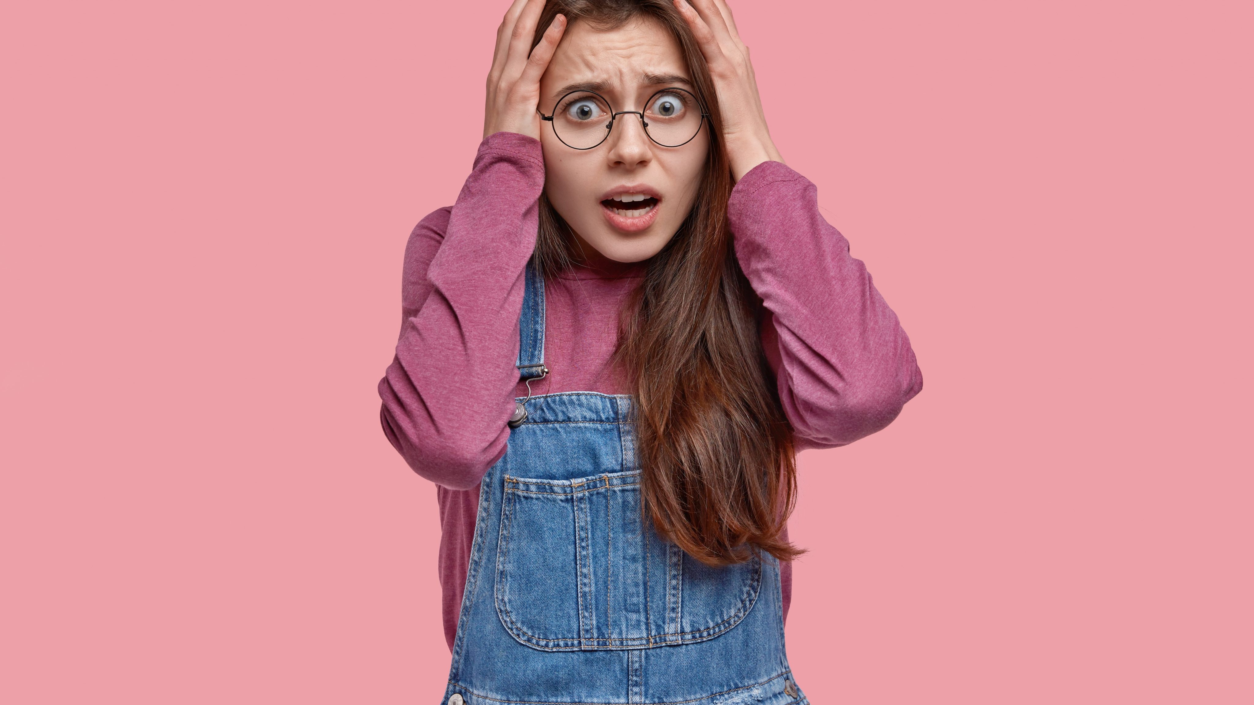 Stressful woman keeps hands head panic has some troubles stares with scared expression dressed fashionable clothes